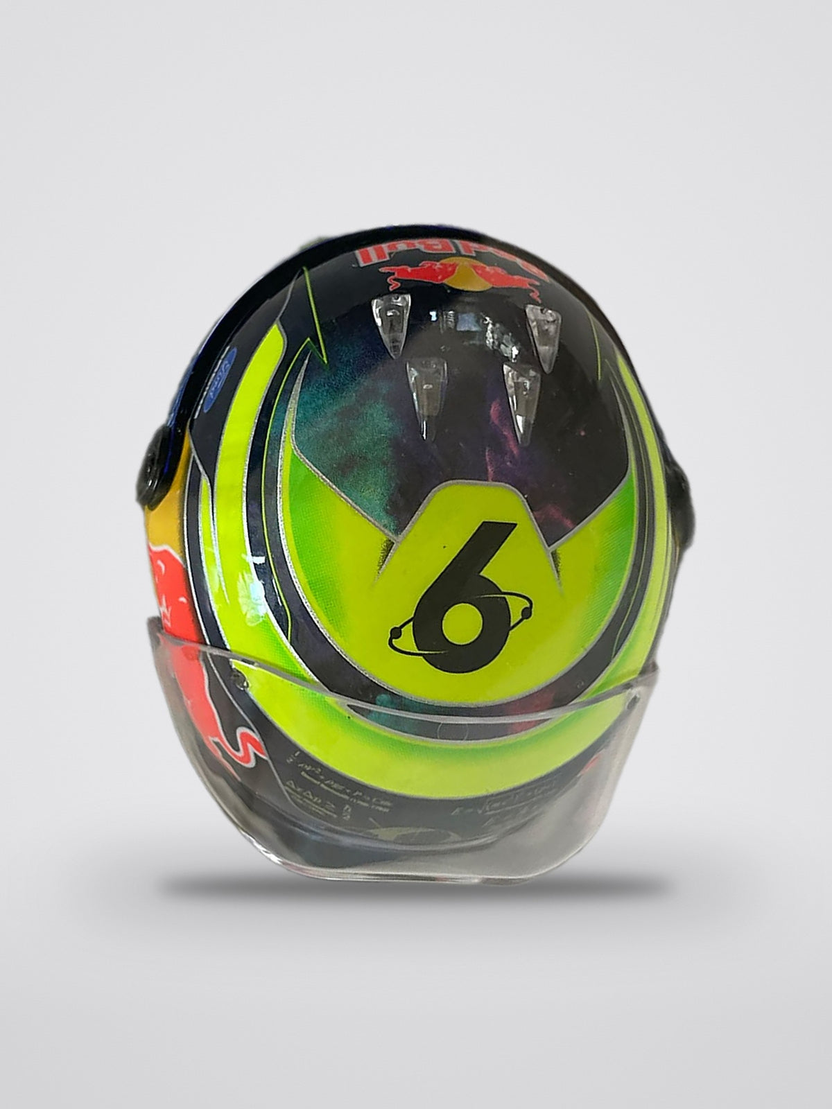Isack Hadjar 2026 season mini helmet, 1:4 scale, top: the No. 6 circled by an orbit