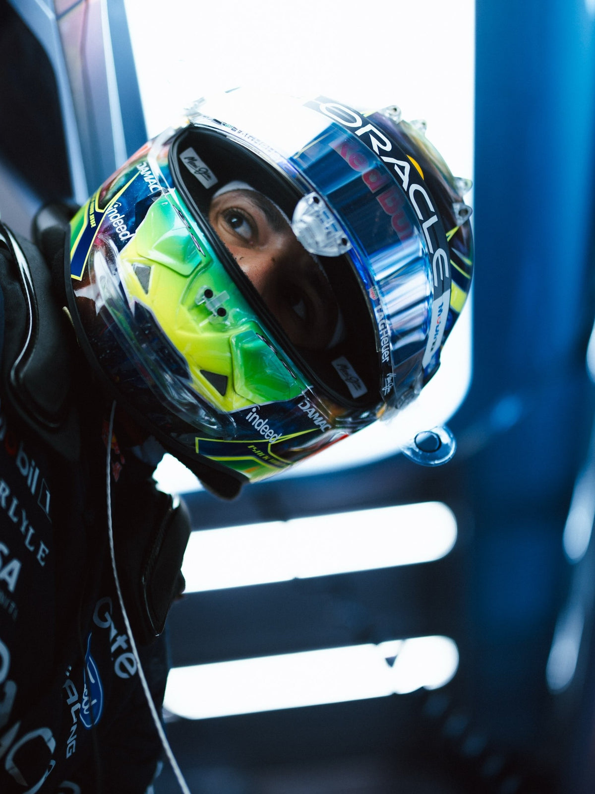 Isack Hadjar in the garage, wearing his full-size 2026 helmet