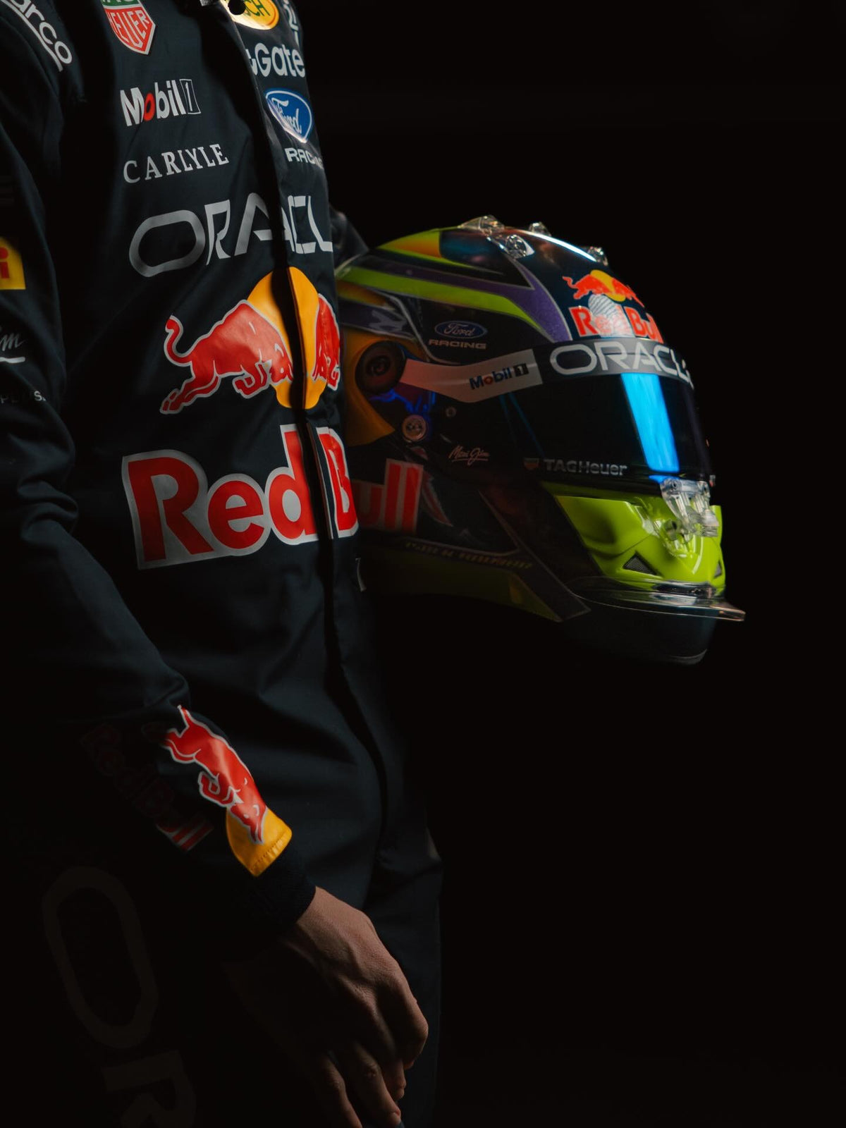 Isack Hadjar in his Oracle Red Bull Racing race suit, holding his 2026 helmet
